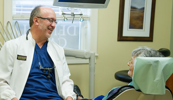 Dr Herzog conversing with an elderly patient